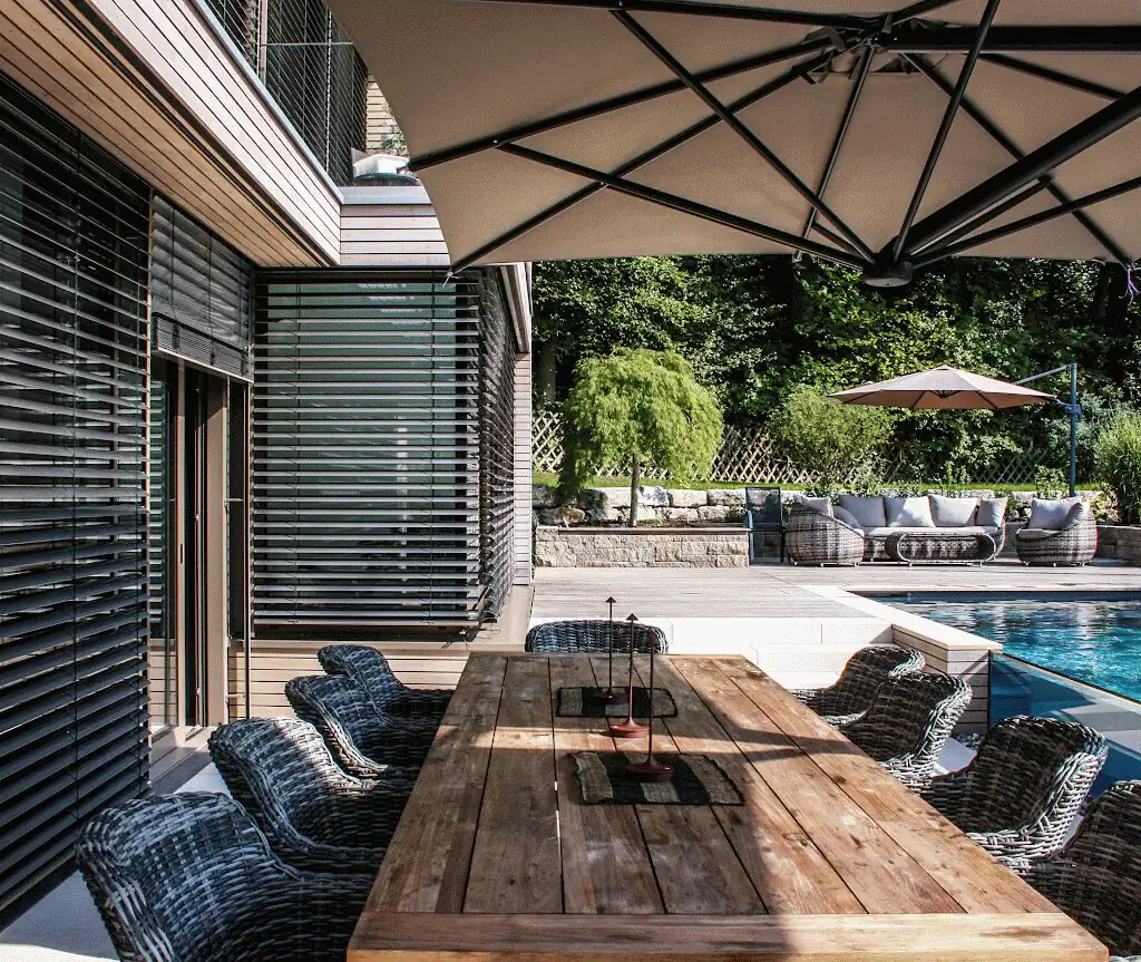 Wooden table under the parasol in front of the house with external blinds in Villingen-Schwenningen