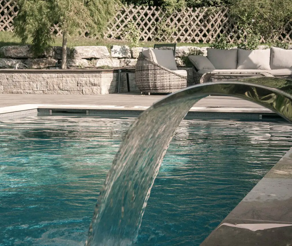 Stainless steel waterfall over the pool in front of the rattan lounge in Villingen-Schwenningen