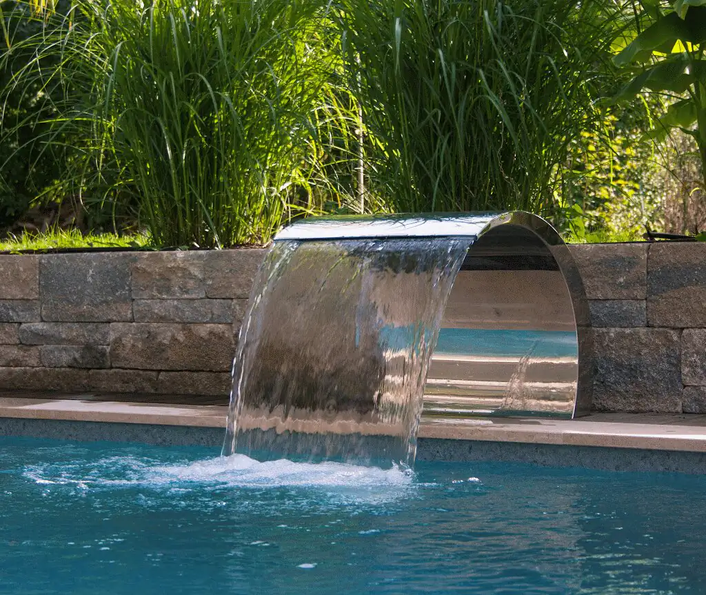 Stainless steel waterfall in front of the natural stone wall with ornamental grasses in Villingen-Schwenningen