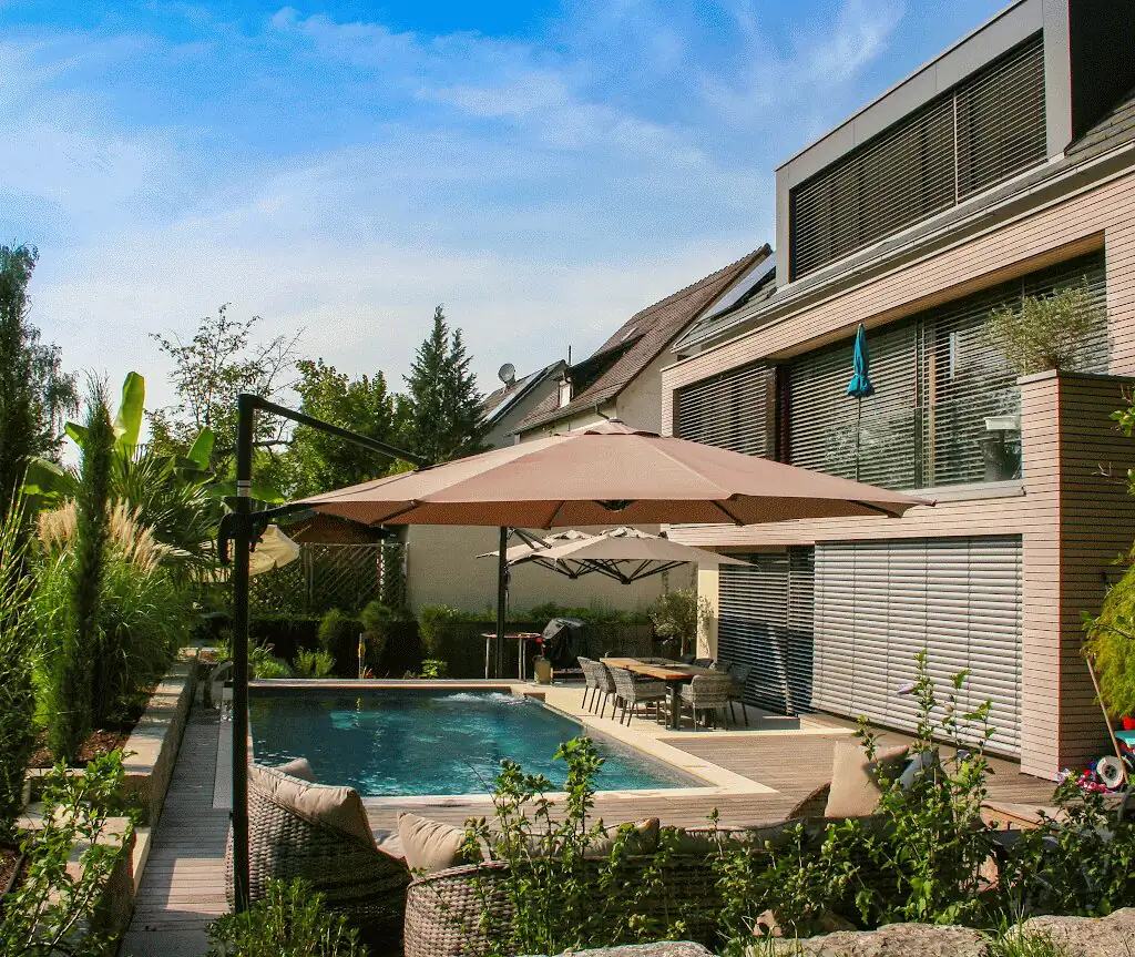 Garden view with pool, parasols and house in Villingen-Schwenningen