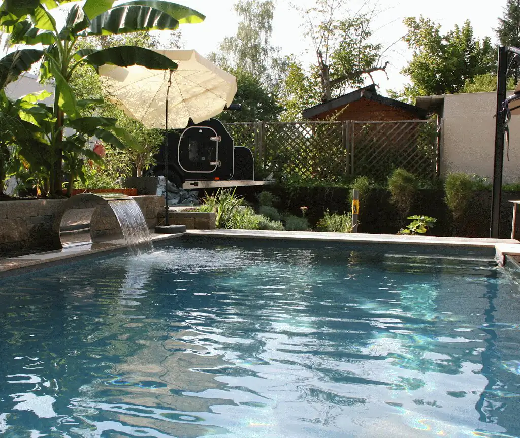 Waterfall and banana plant with parasol behind the pool in Villingen-Schwenningen