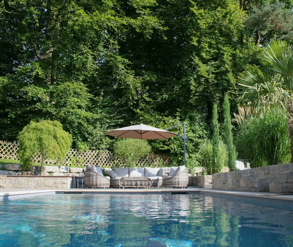 Pool with lounge and natural stone wall, garden behind in Villingen-Schwenningen