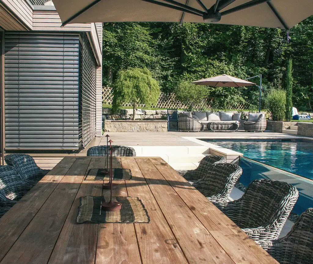 Dining table under the parasol with the pool in the background in Villingen-Schwenningen