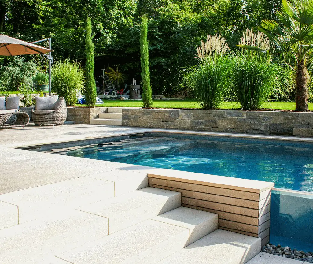Pool with glass wall, steps and ornamental grasses in Villingen-Schwenningen