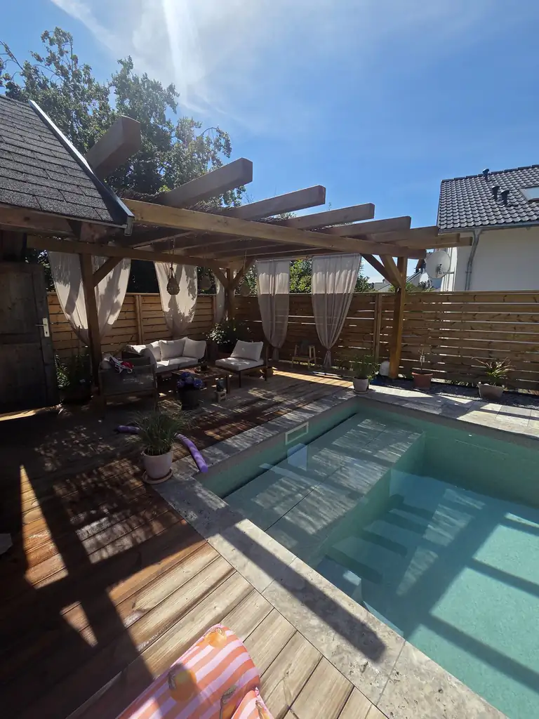 Pool with timber deck under the pergola with lounge area in Villingen-Schwenningen