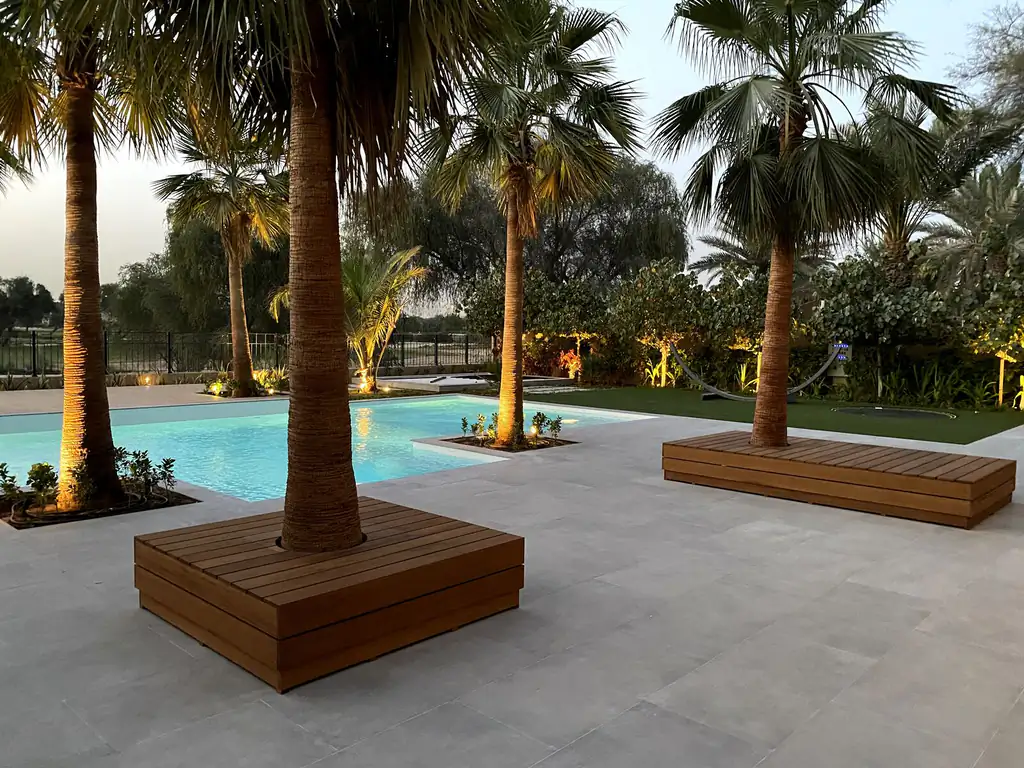 Resort pool under palms, overall view with timber pavilion in Dubai