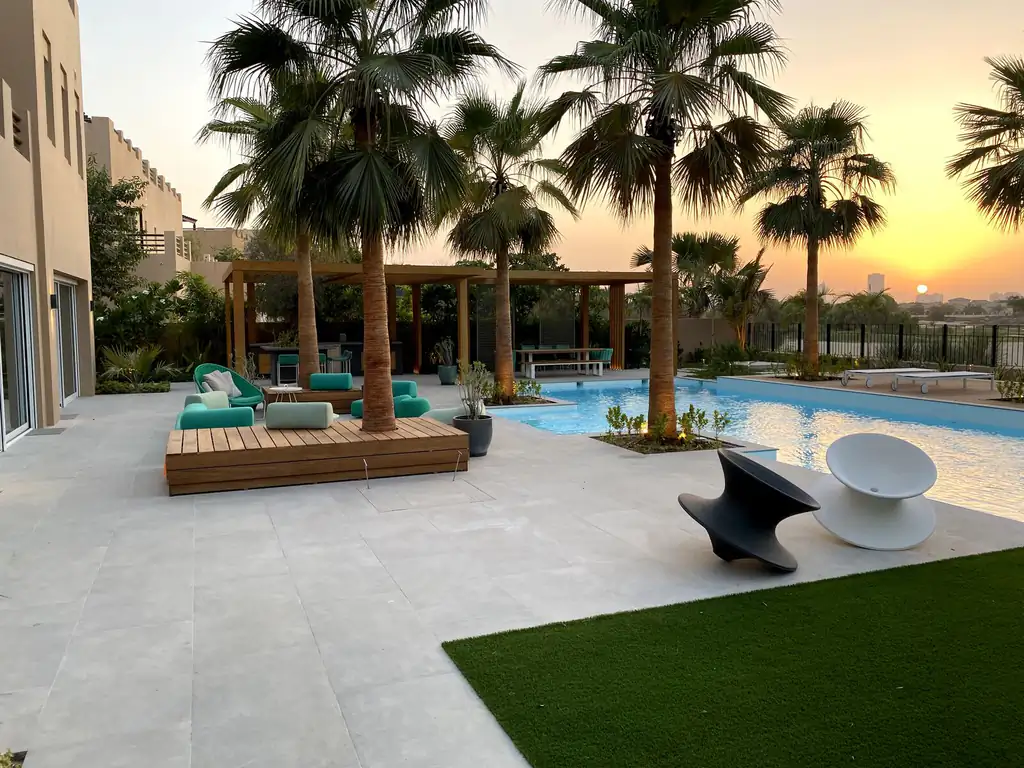 Timber pavilion at the resort pool under palms in Dubai