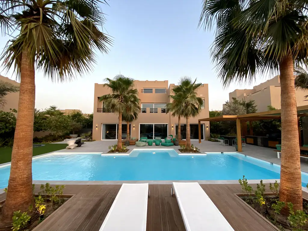 Sunbed area at the resort pool under palms in Dubai